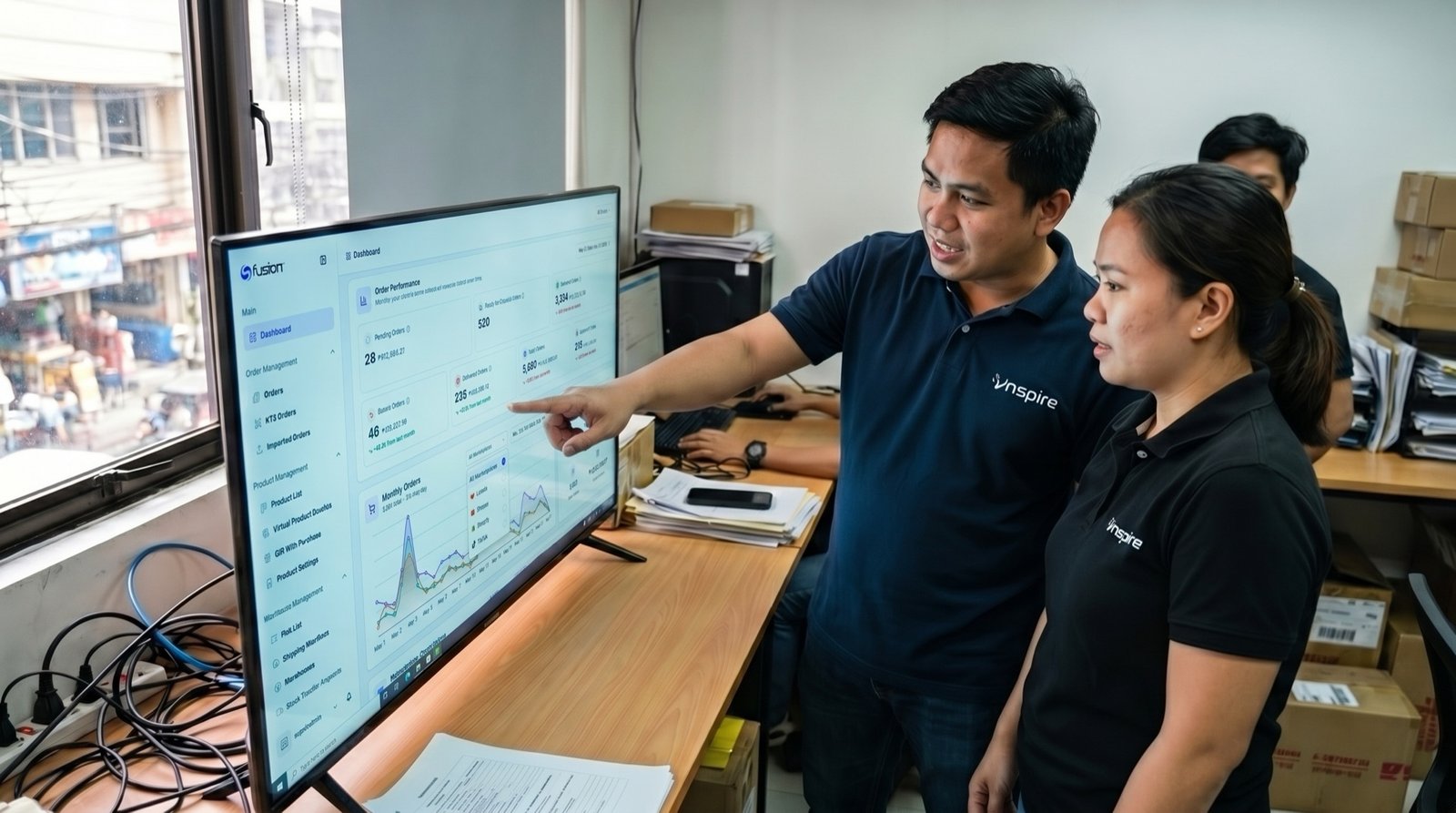 Inspire operators in branded polos reviewing the live Fusion logistics dashboard they built and run