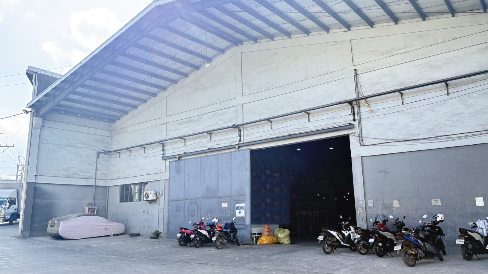 The exterior of a real Inspire fulfillment facility in Metro Manila with the delivery fleet parked outside